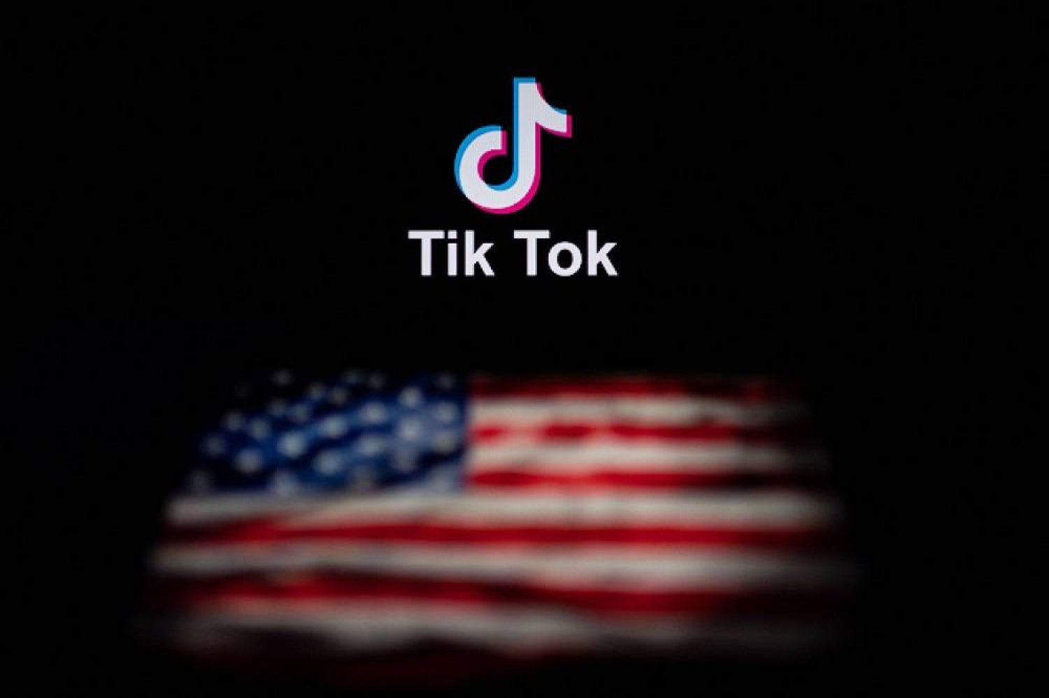  This photo illustration taken on September 14, 2020 shows the logo of the social network application TikTok (top) and a US flag (bottom) shown on the screens of two laptops in Beijing. (AFP)