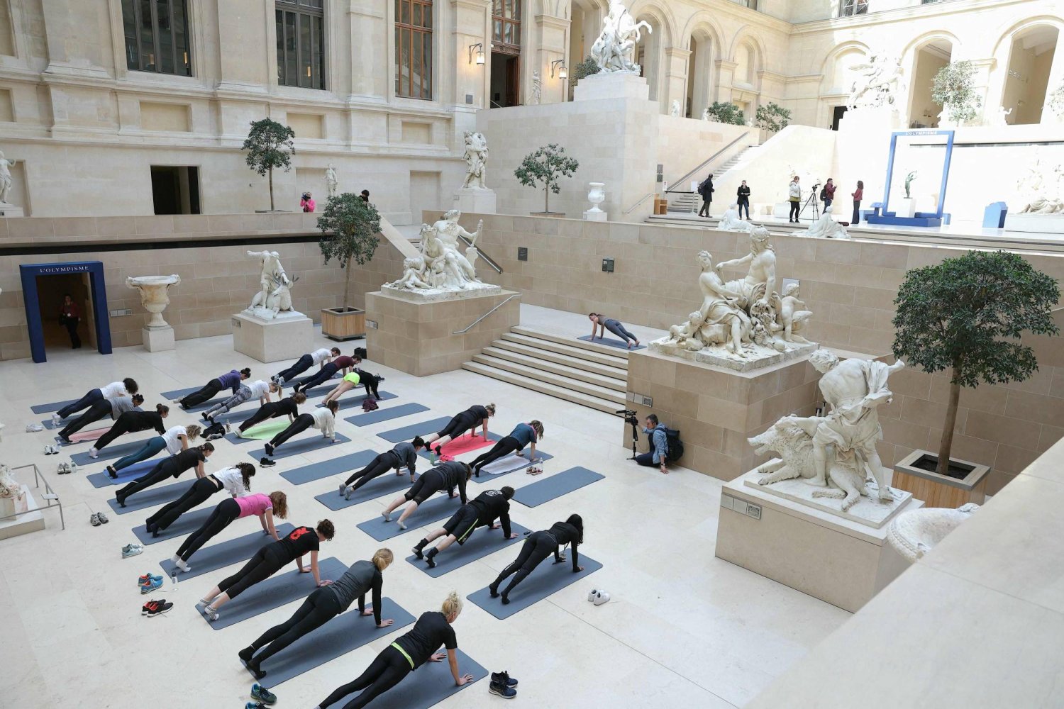 People take part in a rehearsal of "Les visites sportives", an experience proposed by artist and choreographer Mehdi Kerkouche in the Cour Marly at the Louvre Museum in Paris on April 23, 2024. (Photo by Thomas SAMSON / AFP)