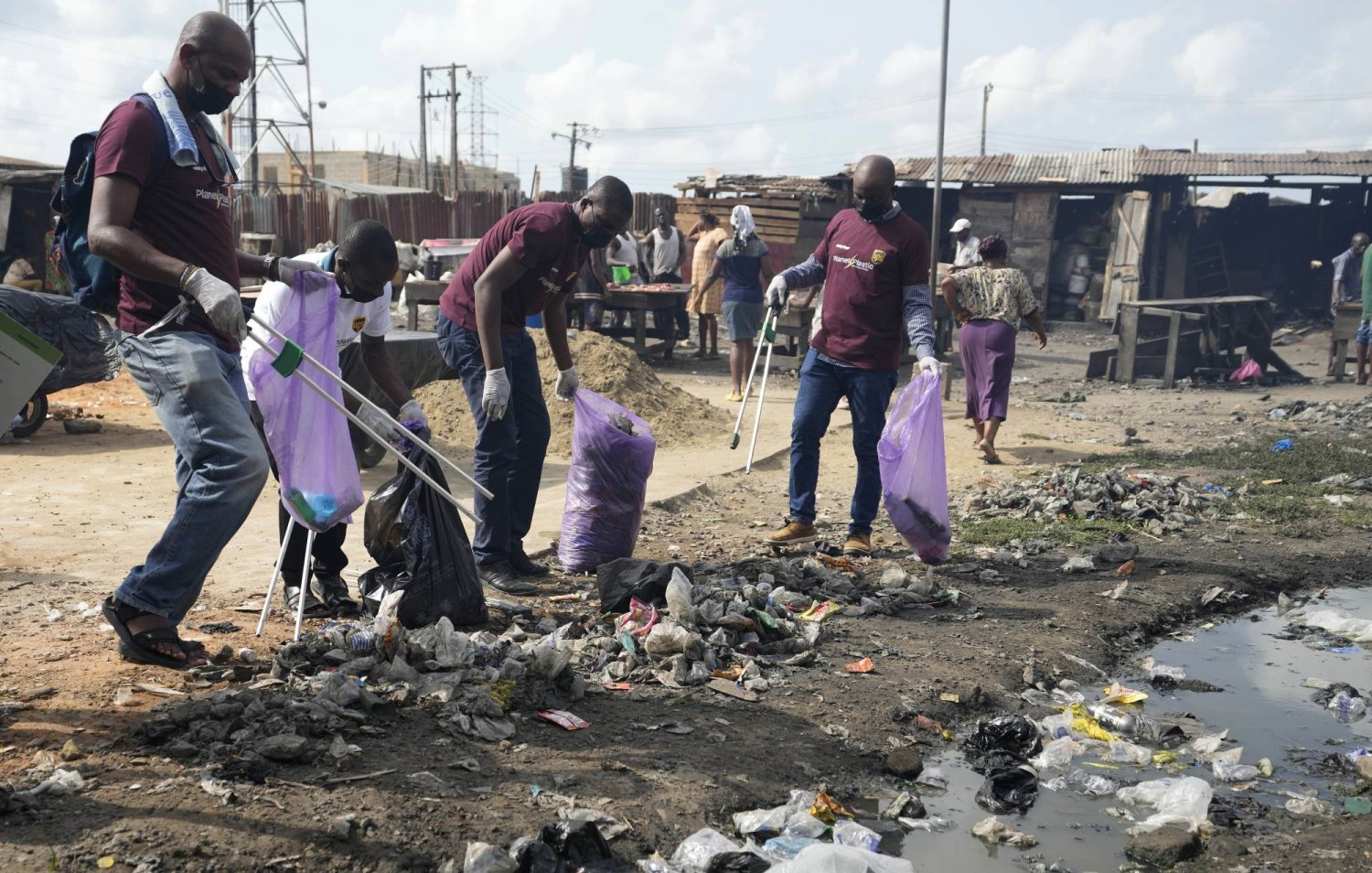 Volunteers from Sustyvibes, a Non-profit organization, pick up trash on a street near a market ahead of World Earth Day, in Lagos, Nigeria, Saturday, April 20, 2024. (AP Photo/Sunday Alamba)