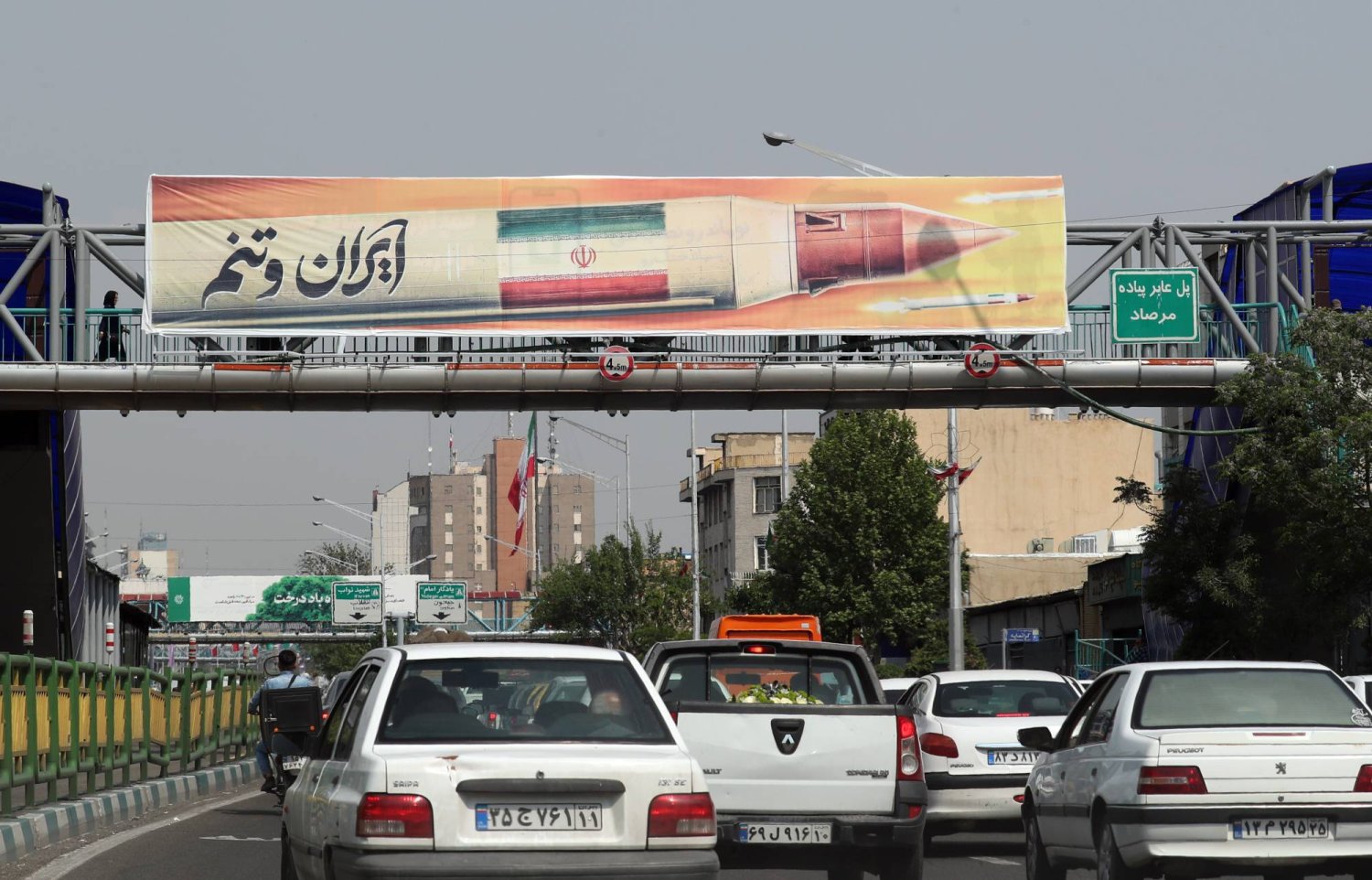 Motorists drive under a billboard of an Iranian missile hanging on a pedestrian bridge in Tehran, Iran, 25 April 2024. EPA/ABEDIN TAHERKENAREH