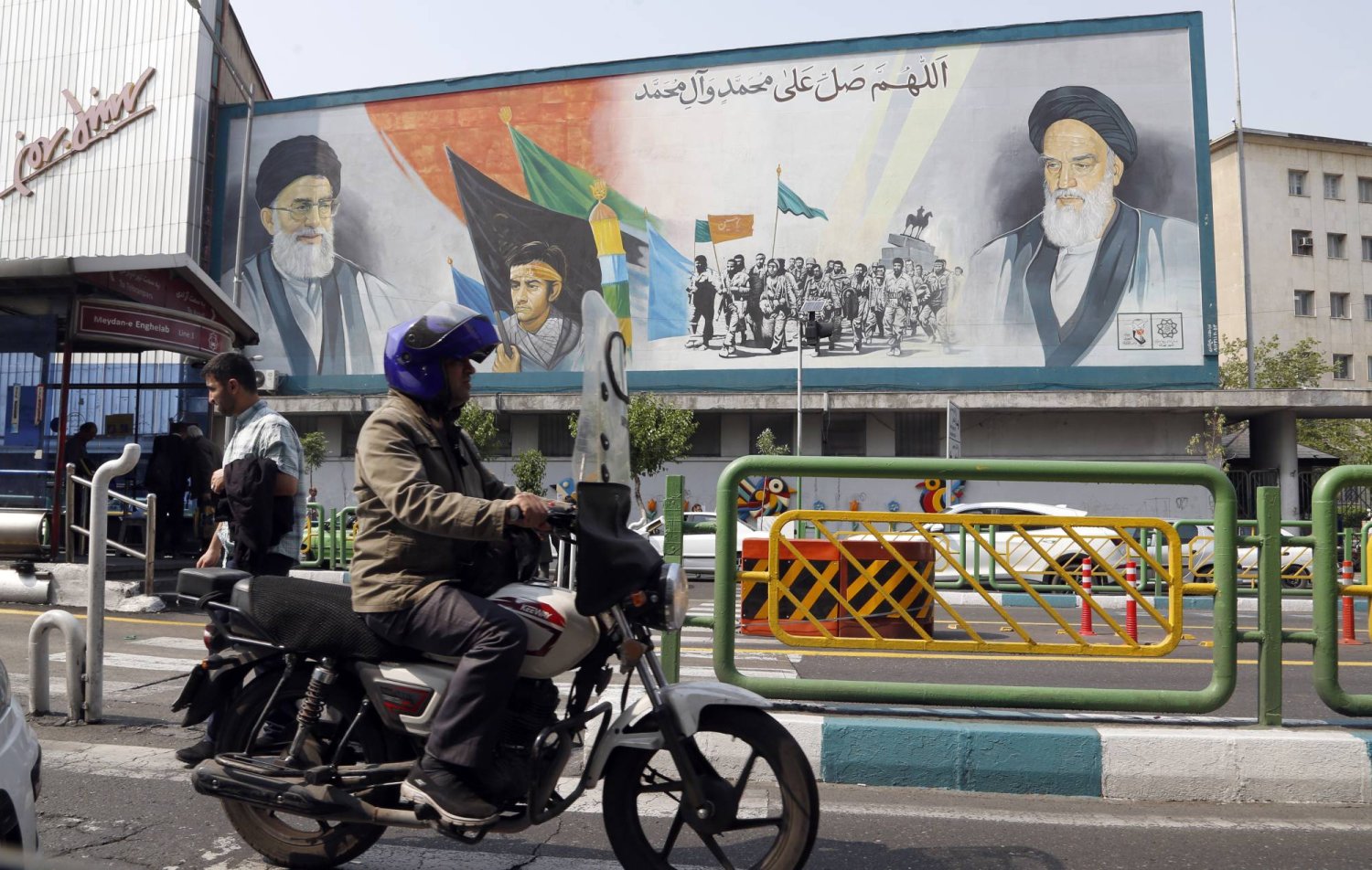 People drive past a wall painting of Iranian supreme leader Ali Khamenei (Top-L) and late supreme leader Ruhollah Khomeini (Top-R) in Tehran, Iran, 25 April 2024. EPA/ABEDIN TAHERKENAREH