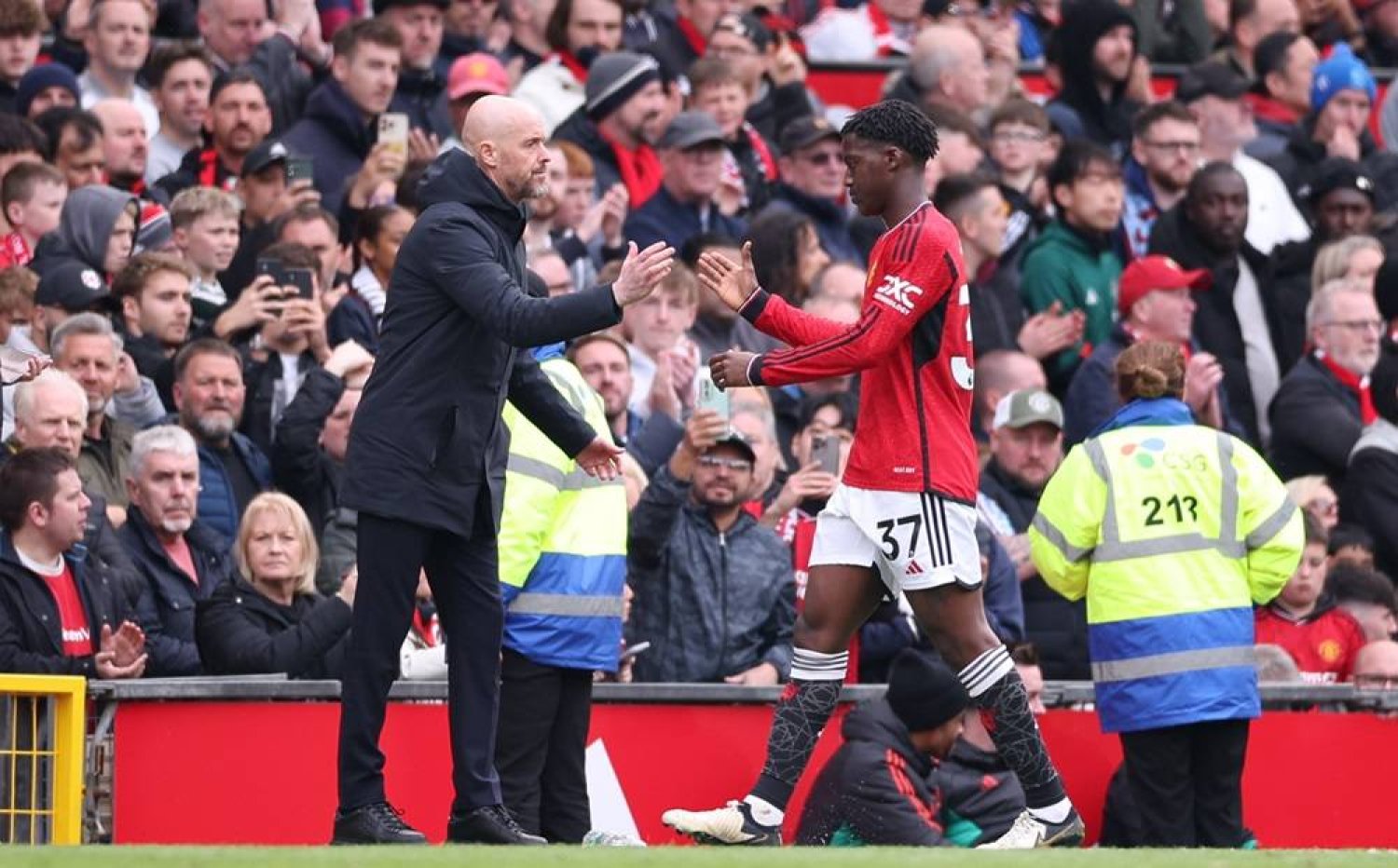 Manchester United manager Erik ten Hag (L) shakes hands with Kobbie Mainoo of Manchester United (R) as he leaves the pitch after being substituted during the English Premier League soccer match between Manchester United and Burnley FC in Manchester, Britain, 27 April 2024. (EPA)