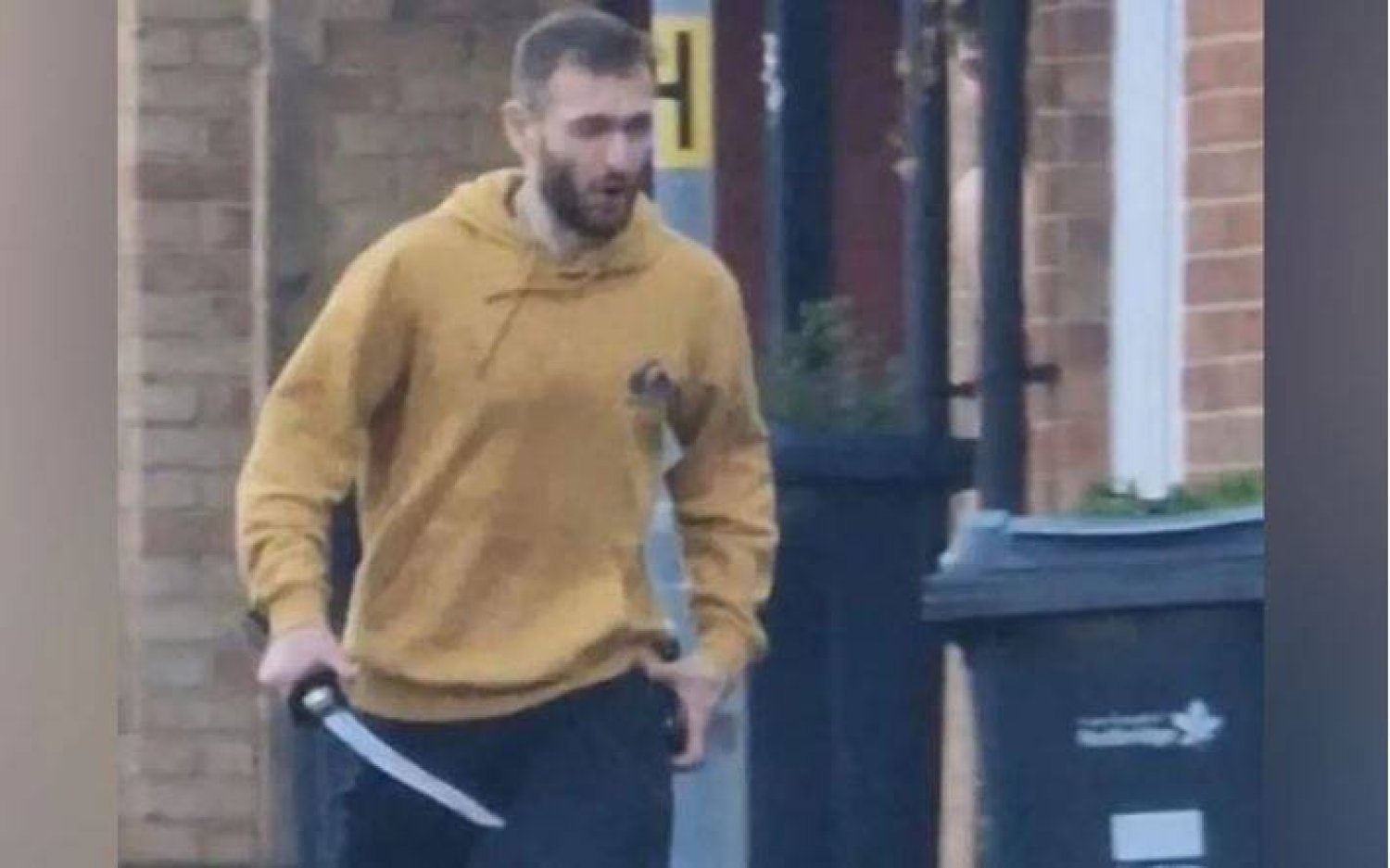 Footage posted on social media appears to show a man wearing a yellow hooded top carrying a large blade. (The Telegraph)
