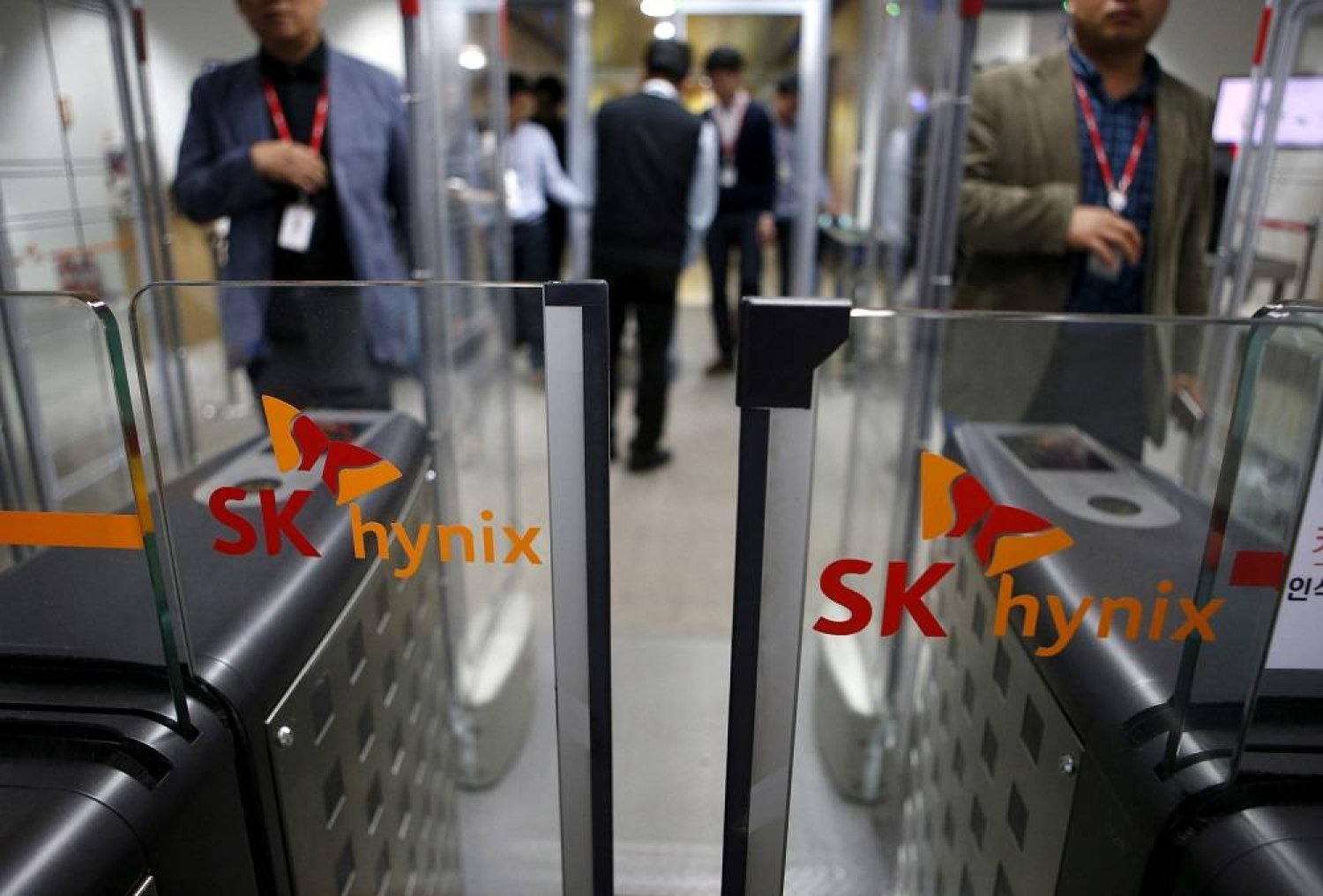 Employees walk past identification systems bearing the logos of SK Hynix at its headquarters in Seongnam, South Korea, April 25, 2016. (Reuters) 