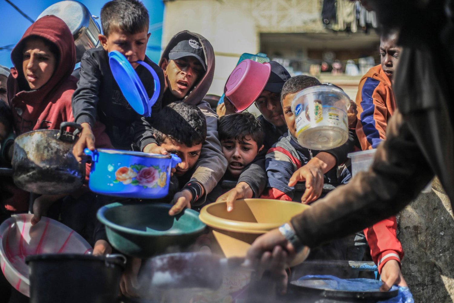FILED - 31 December 2023, Palestinian Territories, Rafah: Palestinian children receive food prepared in a charity kitchen. Photo: Mohammed Talatene/dpa