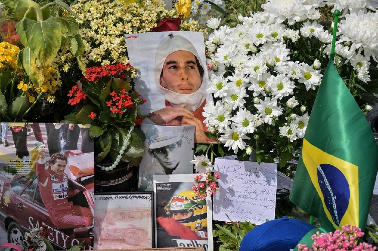 People lay flowers at the grave of Brazilian F1 driver Ayrton Senna in Sao Paulo, Brazil, on May 1, 2024, during the 30th anniversary of his death. (AFP)