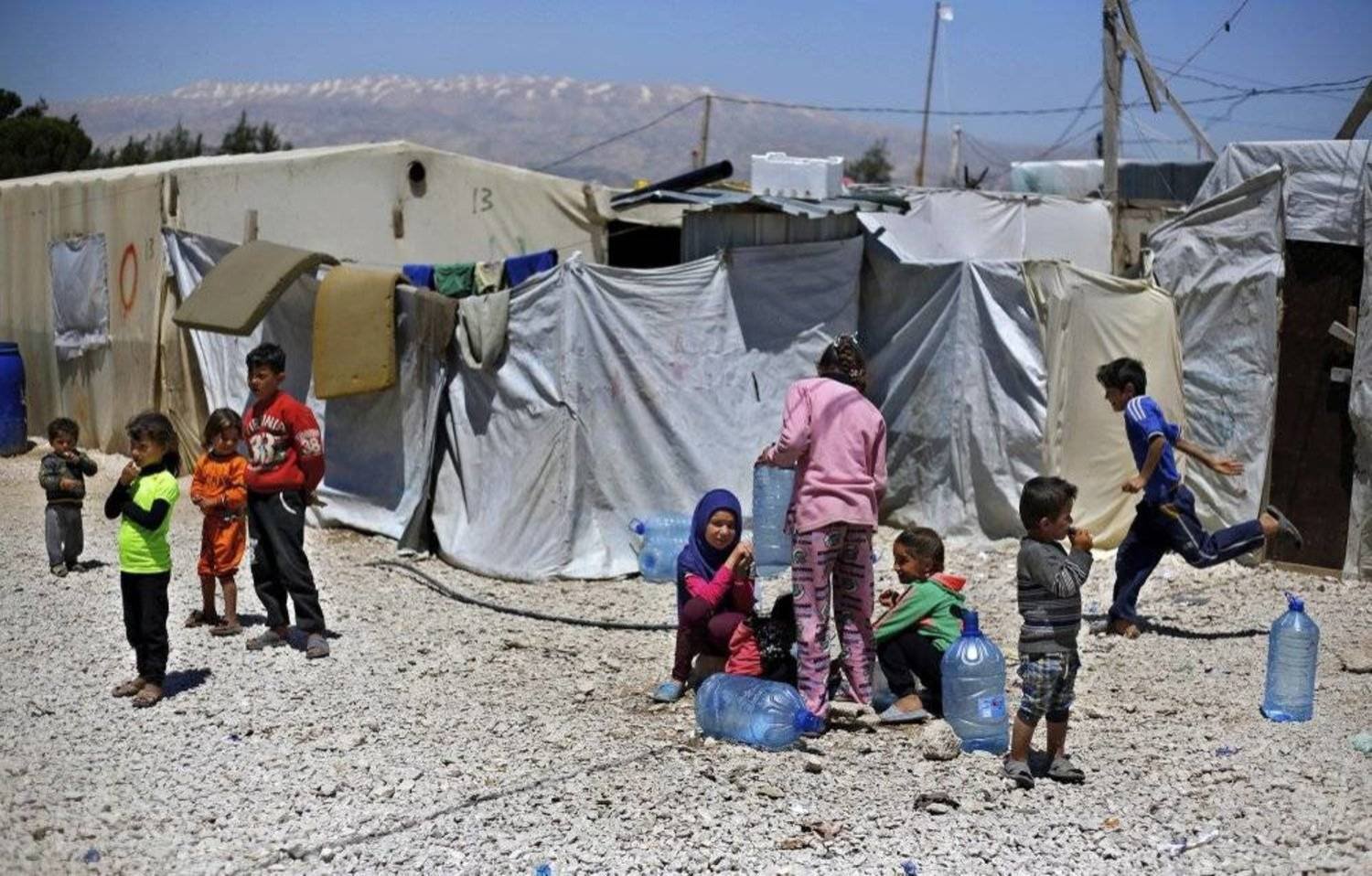 In this Monday, April 23, 2018 photo, Syrian refugee children play outside their family tents at a Syrian refugee camp in the town of Bar Elias, in Lebanon's Bekaa Valley. (AP Photo/Bilal Hussein)
