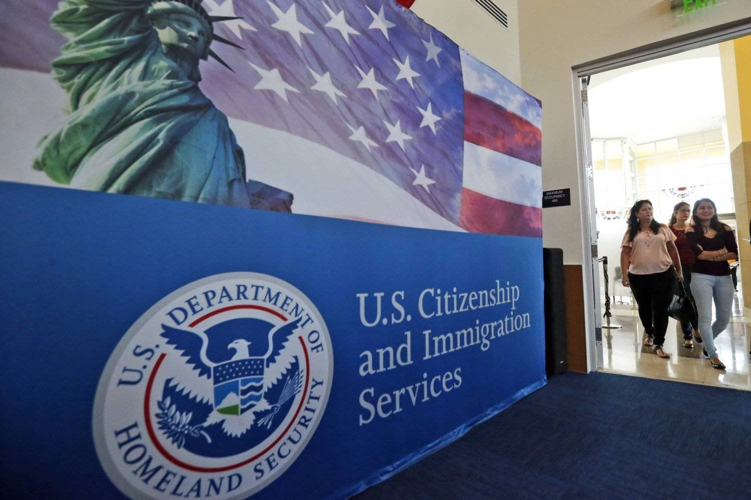 FILE - People arrive before the start of a naturalization ceremony at the US Citizenship and Immigration Services Miami Field Office in Miami, Aug. 17, 2018. (AP Photo/Wilfredo Lee, File)