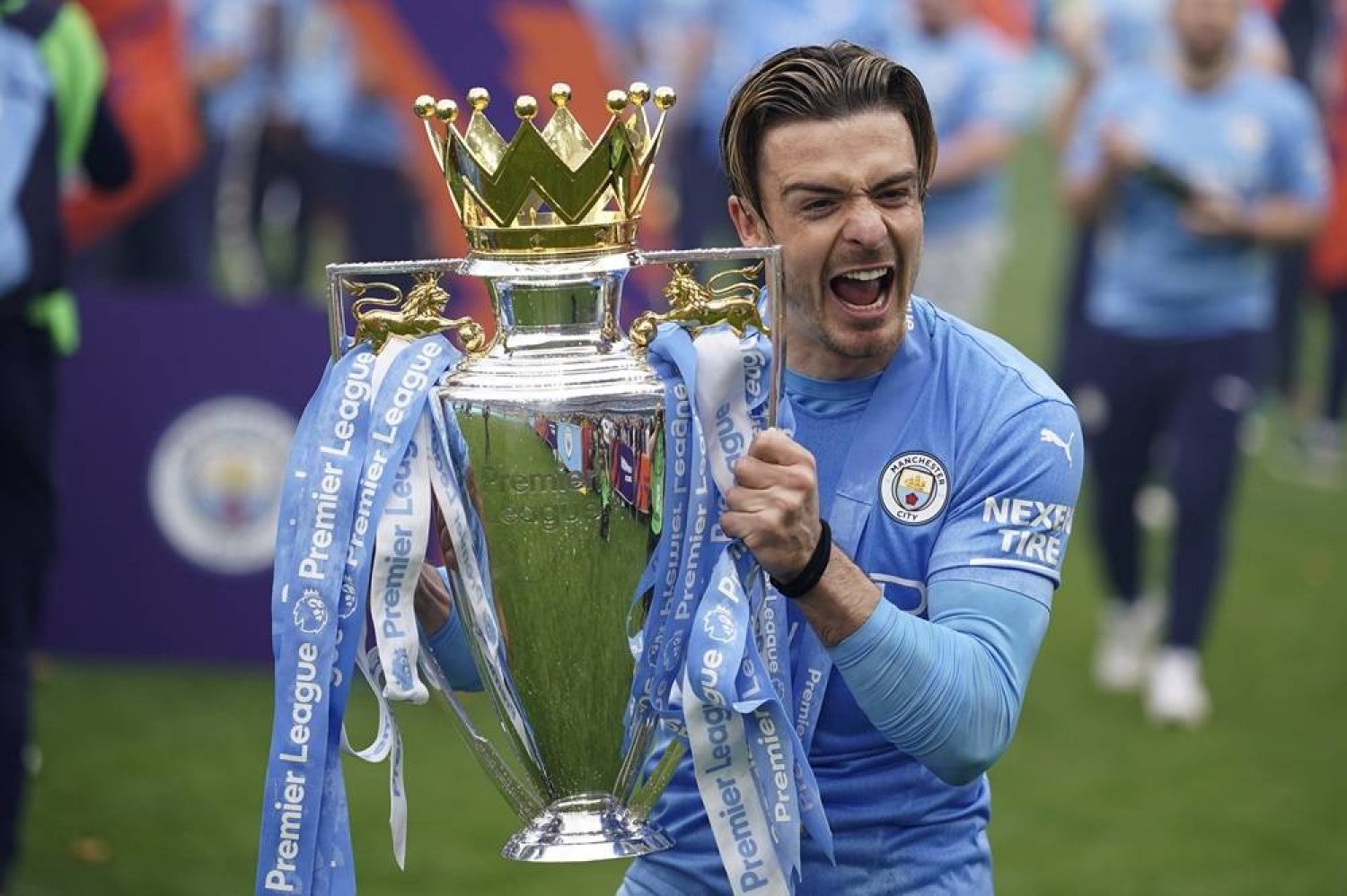 Manchester City's Jack Grealish celebrates with the trophy after winning the 2022 English Premier League title at the Etihad Stadium in Manchester, England, Sunday, May 22, 2022. (AP)
