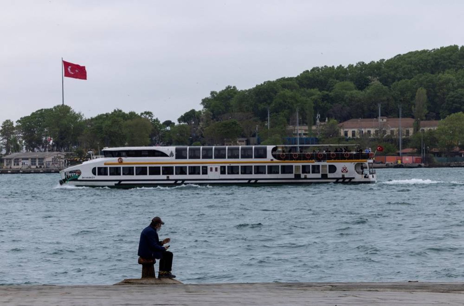  A man enjoys the seaside as a ferry sails through Golden Horn in Istanbul, Türkiye May 1, 2024. (Reuters)