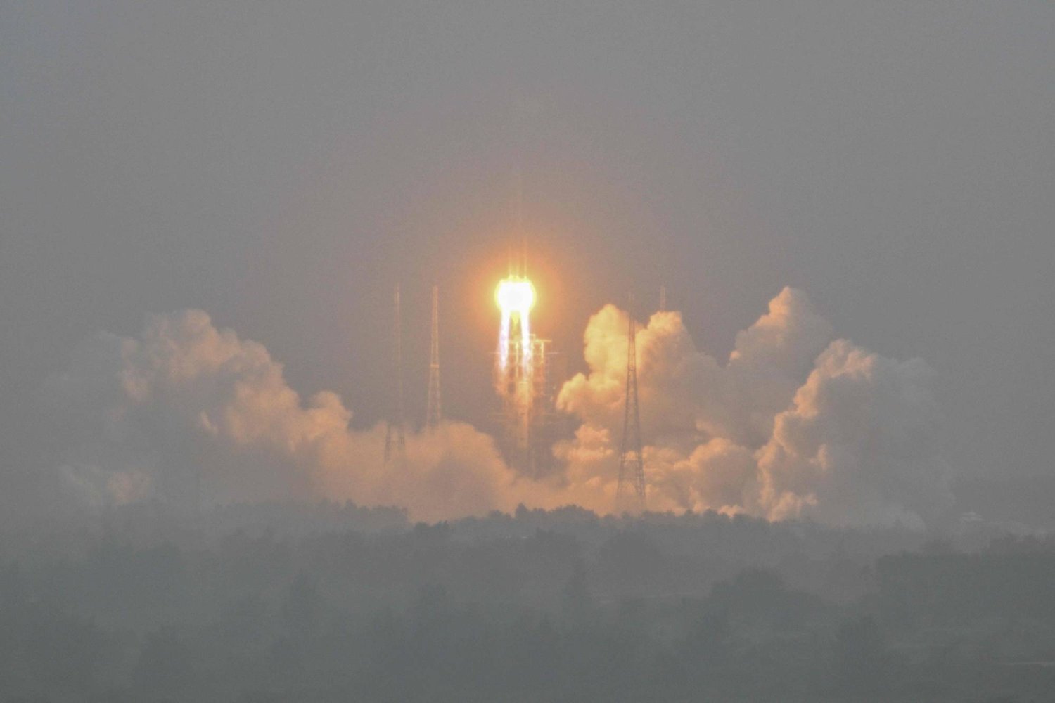 A Long March 5 rocket, carrying the Chang'e-6 mission lunar probe, lifts off as it rains at the Wenchang Space Launch Centre in southern China's Hainan Province on May 3, 2024. (Photo by Hector RETAMAL / AFP)