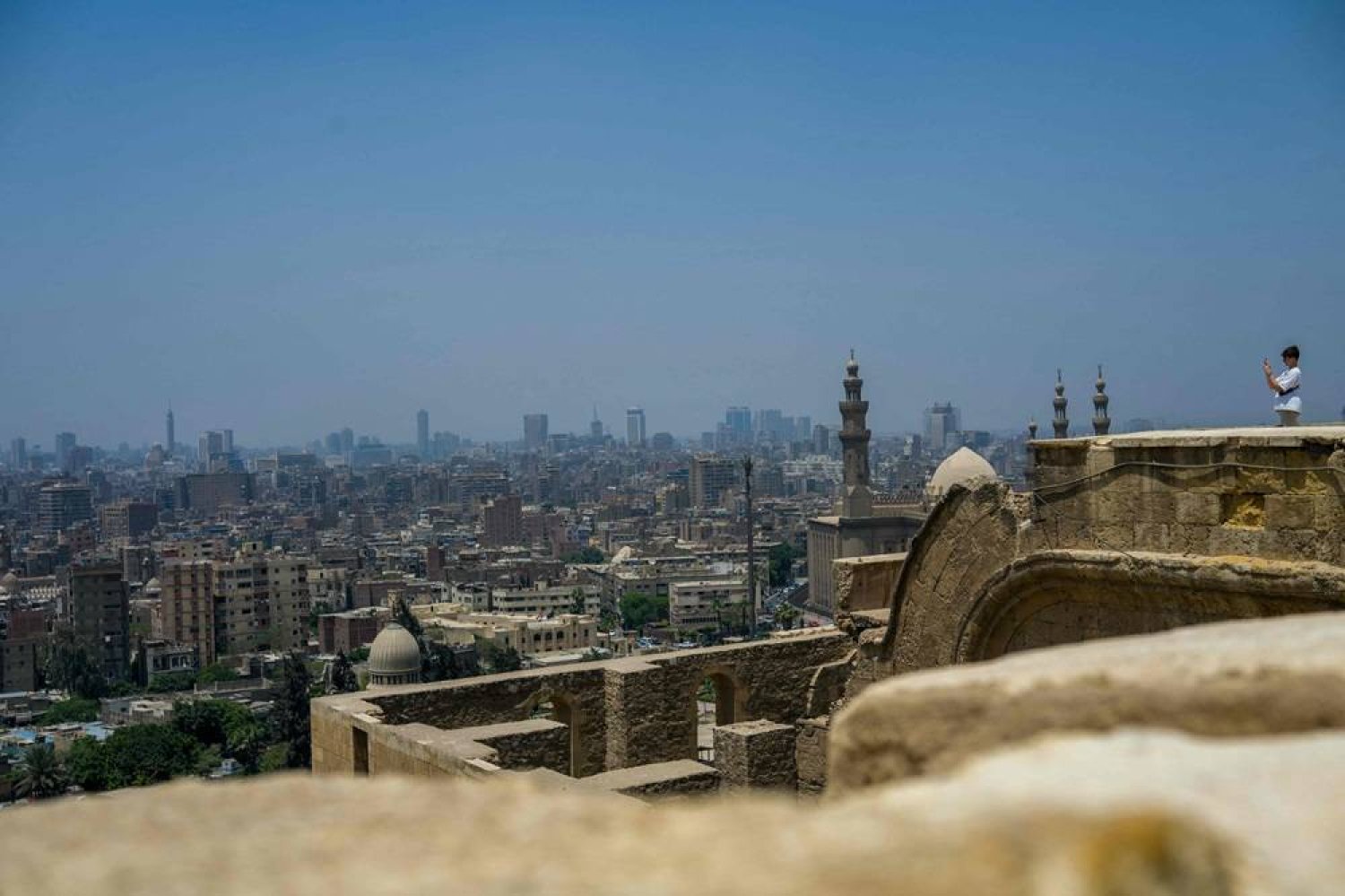  A visitor takes photos of the city from the Salaheddin Citadel in Cairo on May 2, 2024. (AFP) 