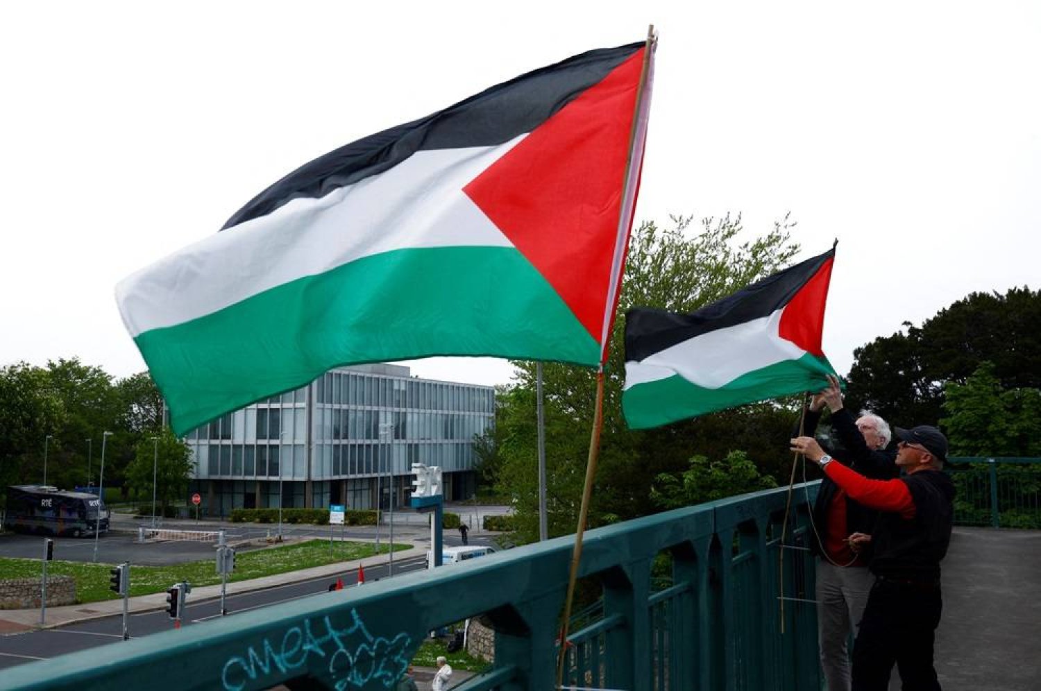  Demonstrators affix Palestinian flags to an overpass ahead of a rally at television station RTE's studios calling for Ireland's national broadcaster to boycott the Eurovision Song Contest because of the Israeli entry, amid the ongoing conflict between Israel and the Palestinian group Hamas, in Dublin, Ireland, May 2, 2024. (Reuters)