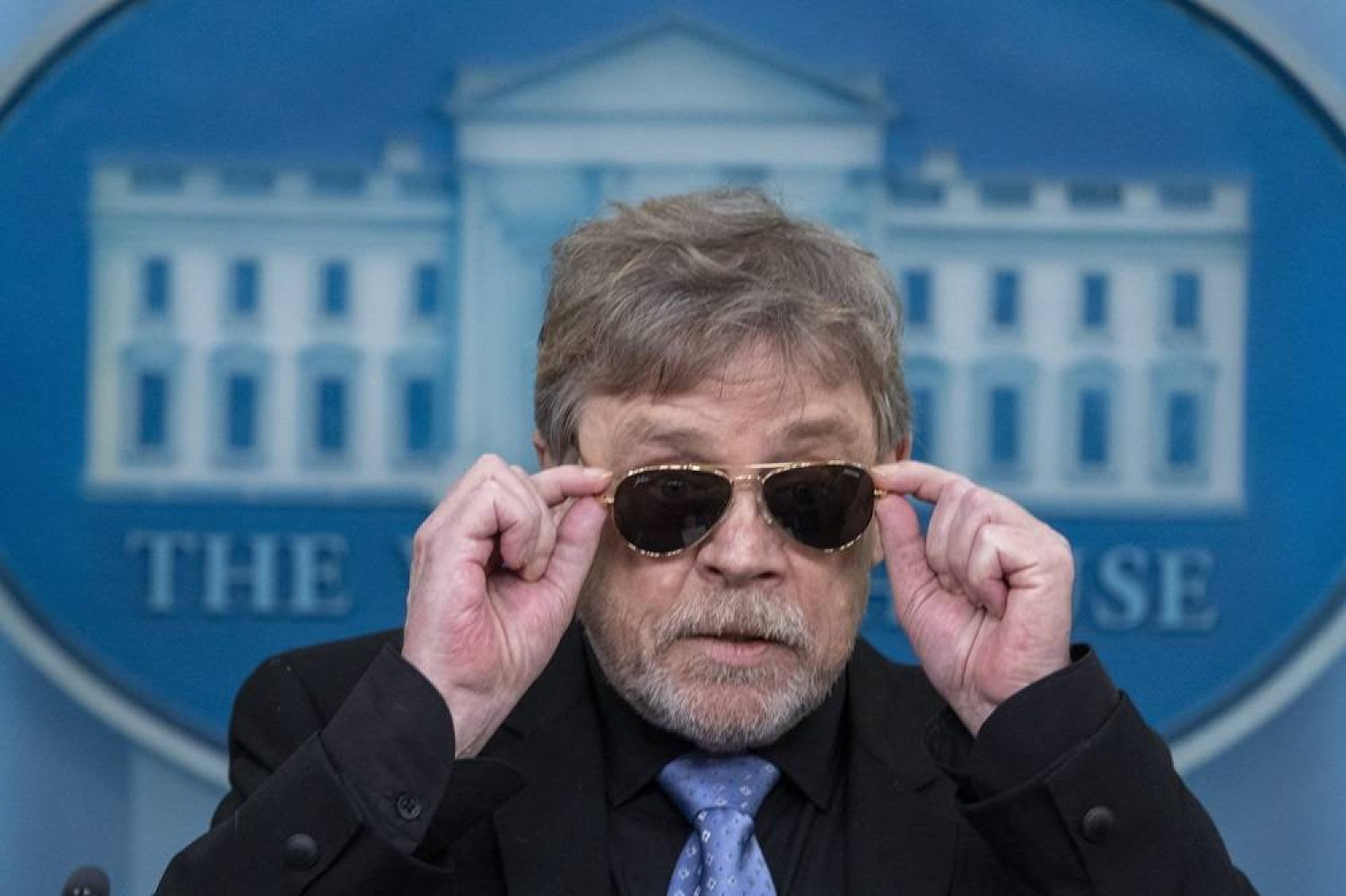  Actor Mark Hamill takes off sunglasses given to him by President Joe Biden, as he joins White House press secretary Karine Jean-Pierre as she speaks with reporters in the James Brady Press Briefing Room at the White House, Friday, May 3, 2024, in Washington. (AP) 
