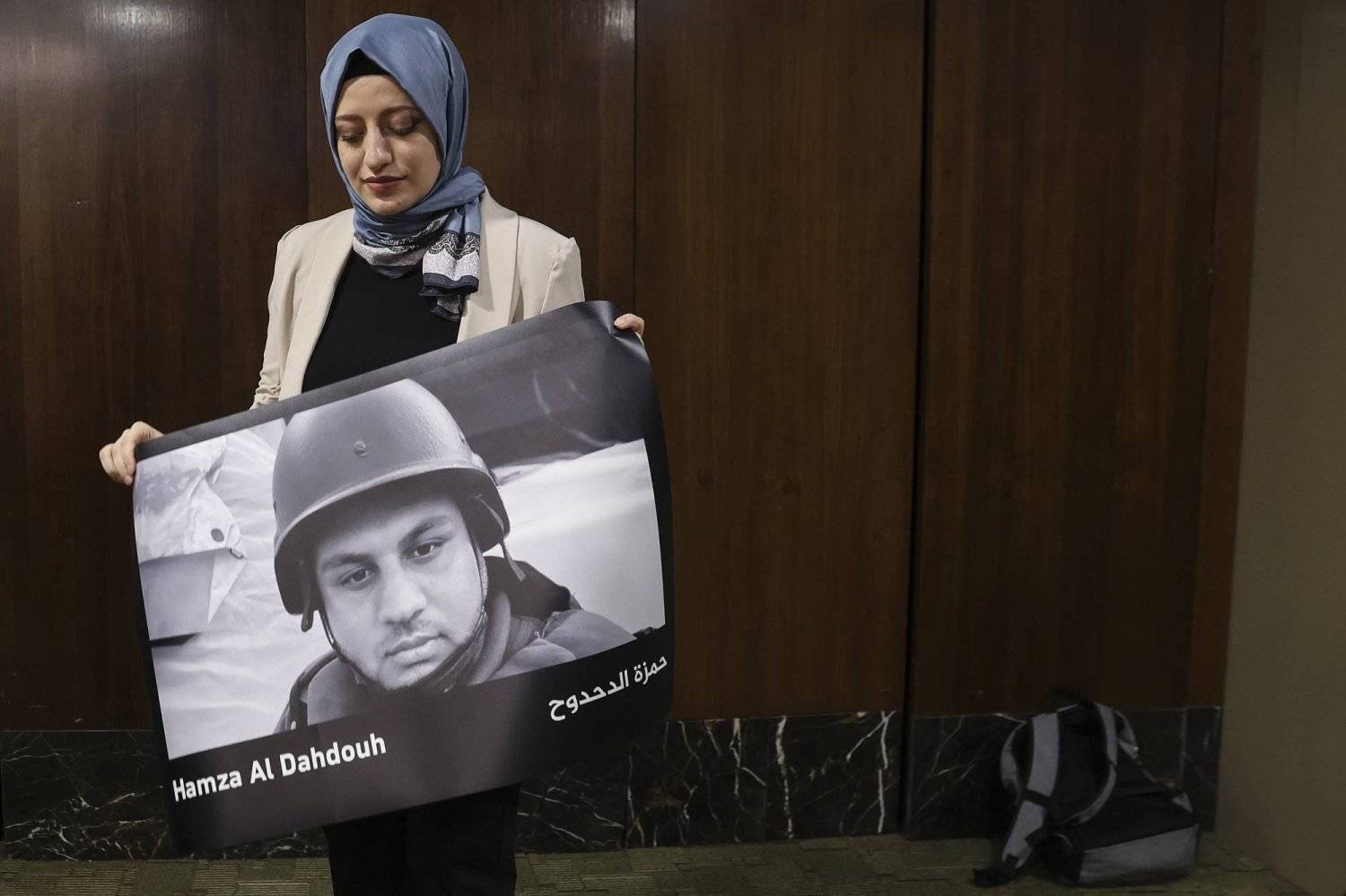 Part of a protest in Kuala Lumpur coinciding with World Press Freedom Day, showing a woman holding a picture of Hamza Al-Dahdouh, Al Jazeera’s correspondent, who was killed during the Israeli war on Gaza (EPA)