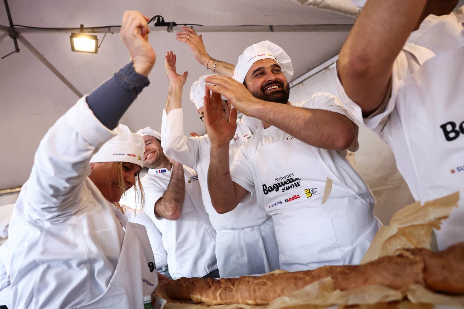 French bakers react after having finished cooking the baguette in an attempt to beat the world record for the longest baguette during the Suresnes Baguette Show in Suresnes near Paris, France, May 5, 2024. REUTERS/Stephanie Lecocq