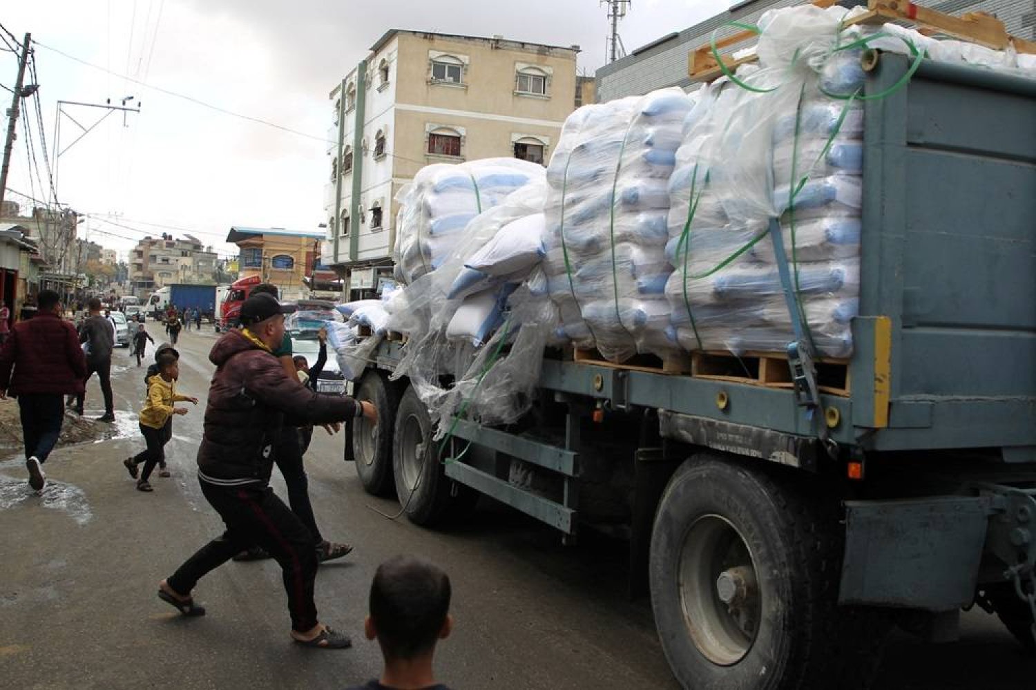 People grab flour bags from a truck after the Israeli military began evacuating Palestinian civilians ahead of a threatened assault on Rafah, amid the ongoing conflict between Israel and Hamas, in Rafah, in the southern Gaza Strip May 6, 2024. (Reuters)