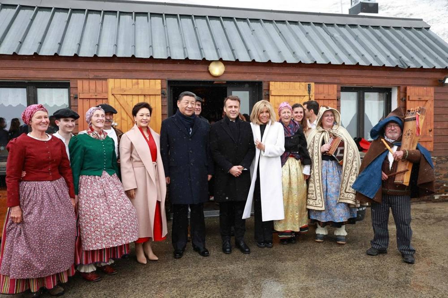 French President Emmanuel Macron (C-R) and his wife Brigitte Macron (4thR), Chinese President Xi Jinping (C-L) and his wife Peng Liyuan (4thL) pose with folklore dancers at the Tourmalet pass, in the Pyrenees mountains, as part of his two-day state visit to France, on May 7, 2024. (AFP)