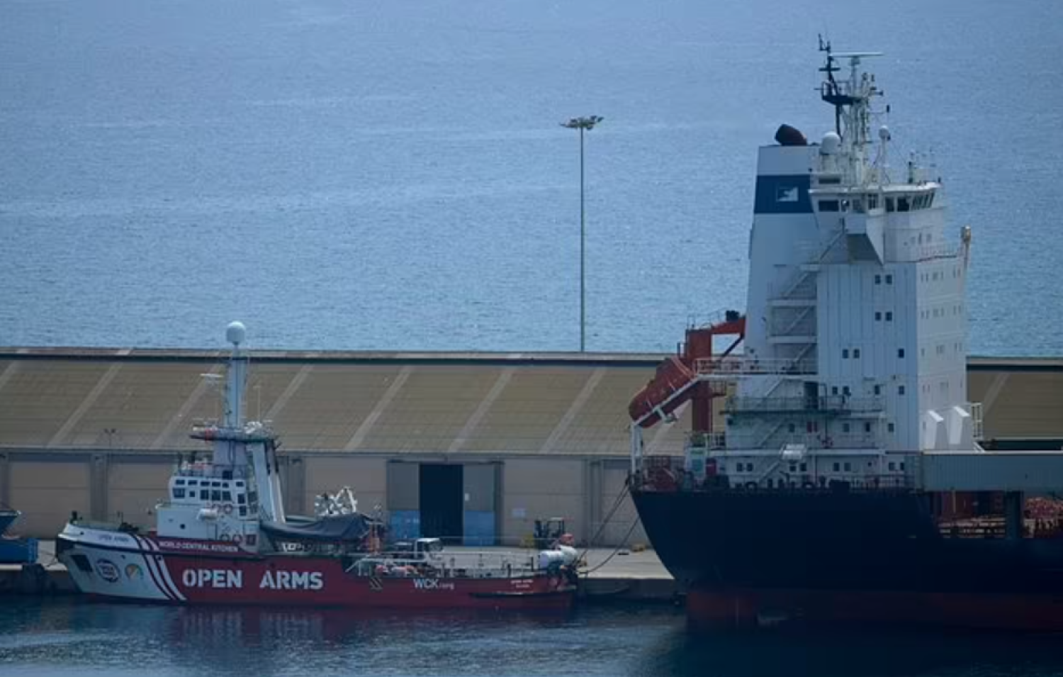 A view of the open arms ship and the container ship Sagamore, right, docked at Larnaca port, Cyprus, Wednesday, May 8, 2024, where food heading to Gaza is being loaded for eventual delivery. (AP Photo/Petros Karadjias)


