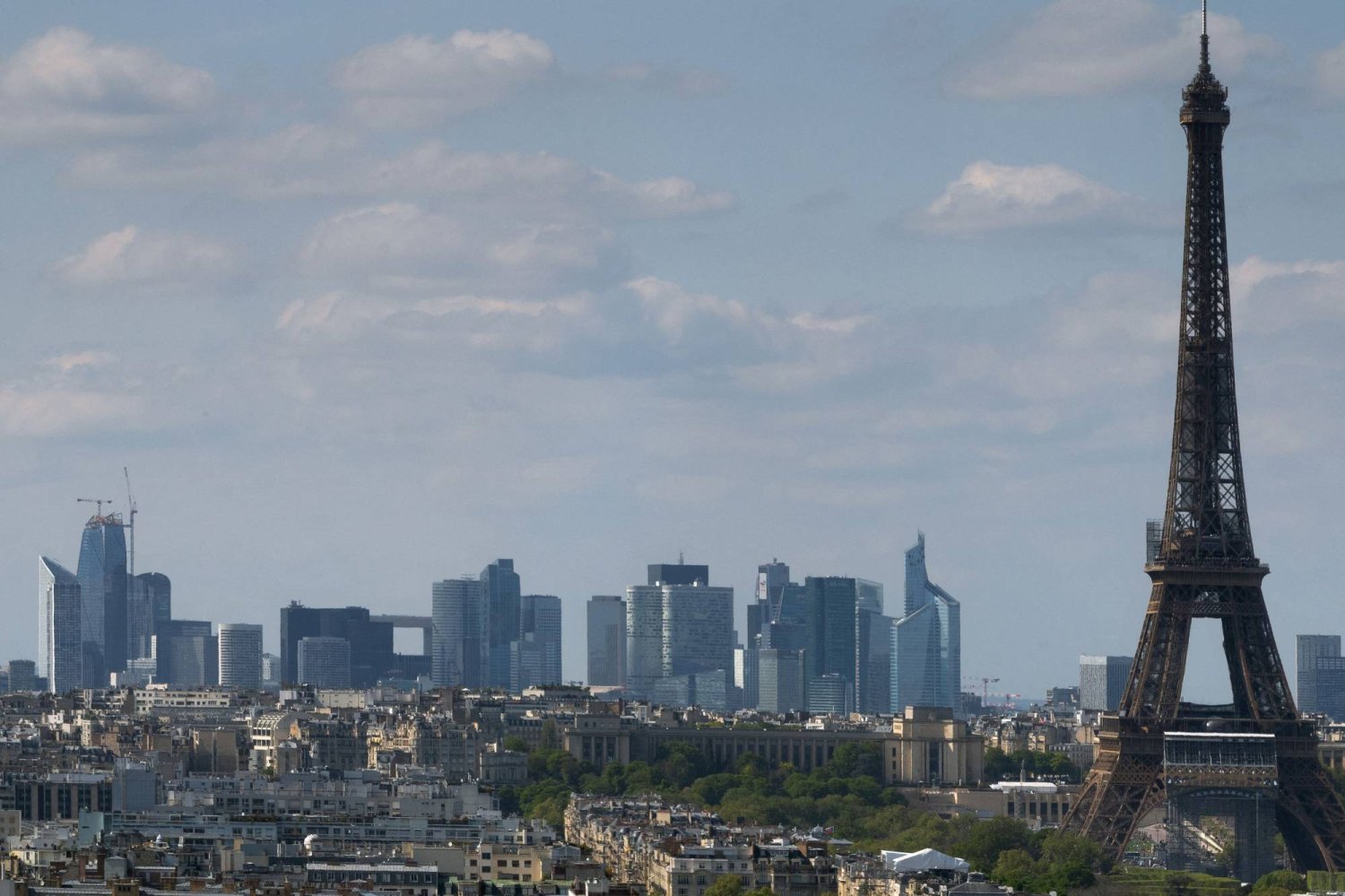 (FILES) This photograph taken in Paris on April 22, 2022 shows the Eiffel Tower with La Defense business district in the background. (Photo by JOEL SAGET / AFP)