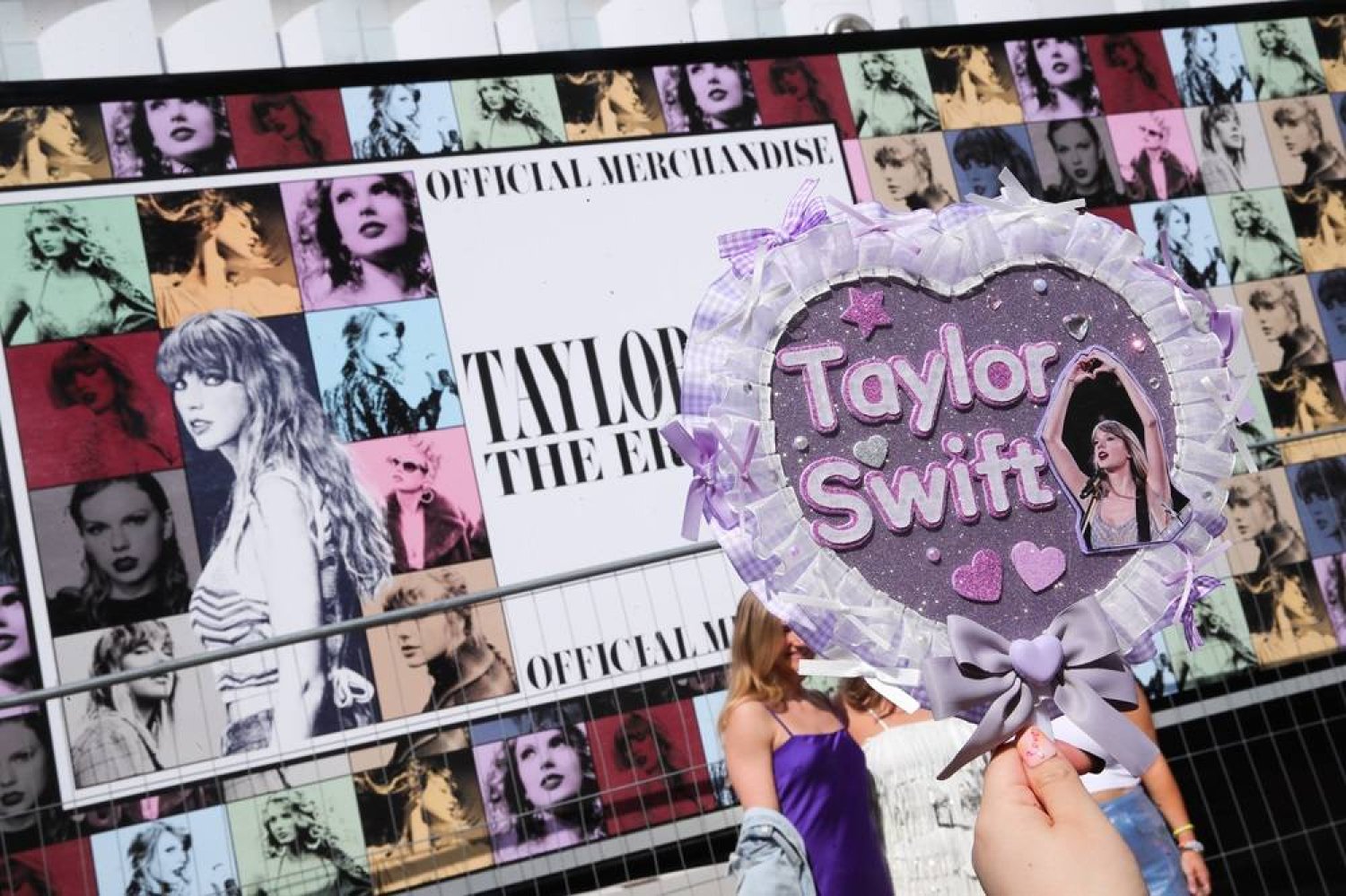 A Taylor Swift fan takes a picture of a handmade sign next to the poster of Taylor Swift's “Eras Tour” first concert in Europe, at the Paris La Defense Arena in Nanterre, suburbs of Paris, France, 09 May 2024. (EPA) 
