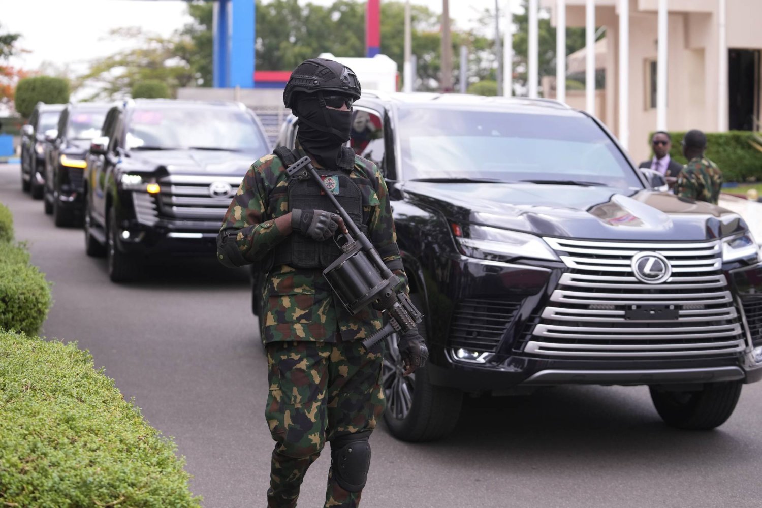 A military officer stand guards in front of a car carrying Prince Harry and Meghan during there visit at the Defense headquarters in Abuja, Nigeria, Friday, May 10, 2024. (AP Photo/Sunday Alamba)