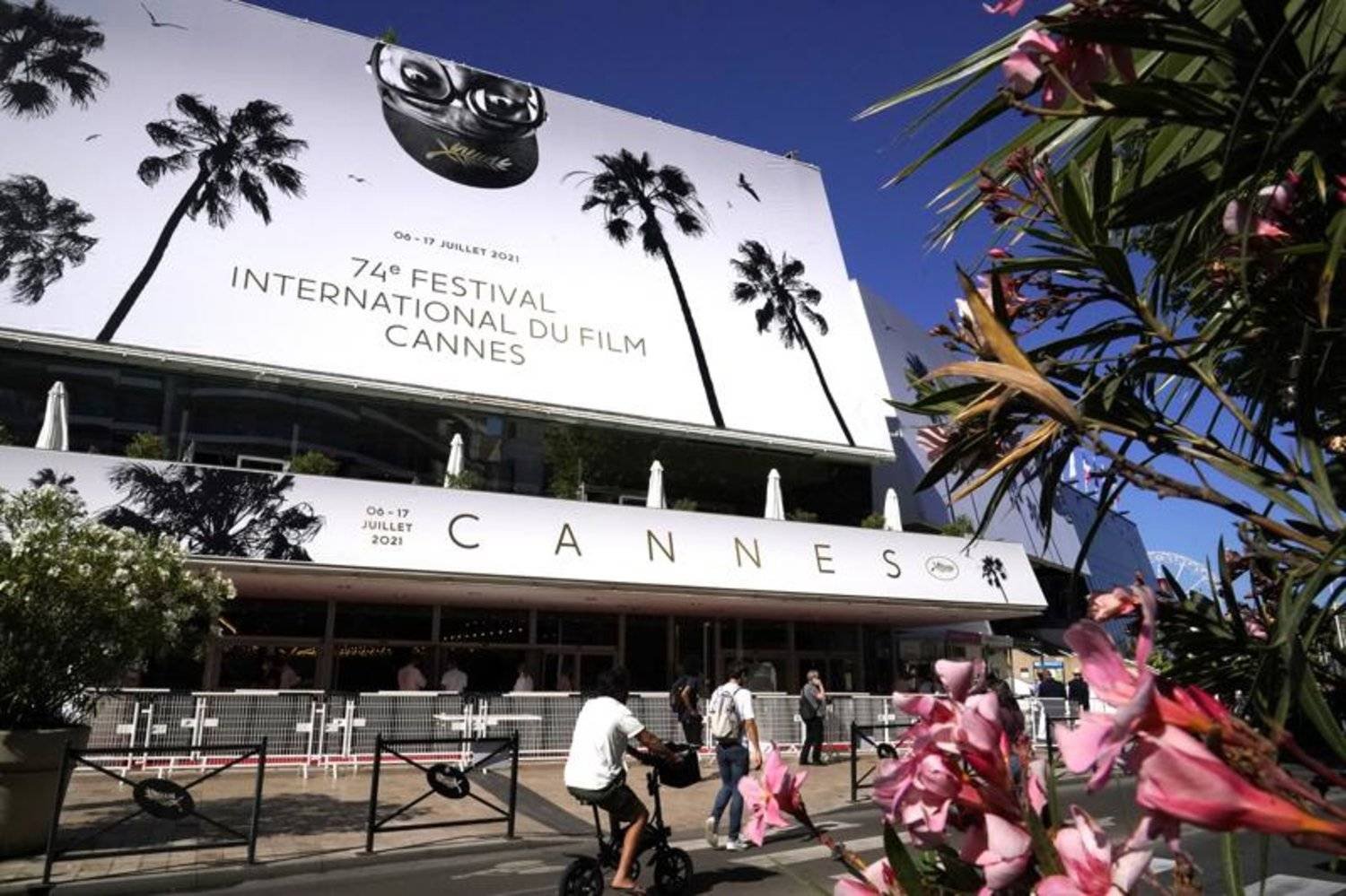 Members of the public walk in front of the Palais des Festival prior to the 74th international film festival, Cannes, southern France, July 5, 2021. (AP Photo/ Brynn Anderson)
