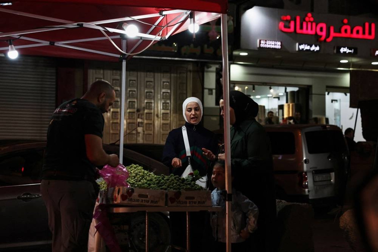  Palestinian women shop at a roadside stand near Ramallah, in the Israeli-occupied West Bank, May 3, 2024. (Reuters)